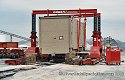 Transformer arrives via one of Emmert's heavy-duty rail flatcars, 
                    and is being ready for unloading with Emmert's Gantries