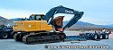 Driving excavator on top of wood beams in order to clear lowboy bed
