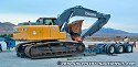 Driving excavator on top of wood beams in order to clear lowboy bed