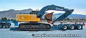 Driving excavator on top of wood beams in order to clear lowboy bed