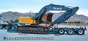 Driving excavator on top of wood beams in order to clear lowboy bed